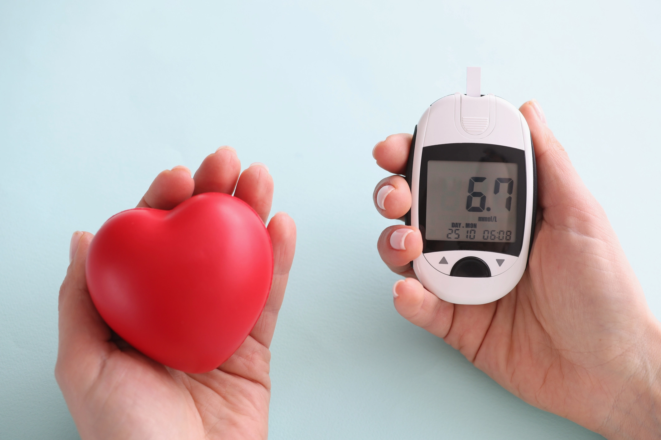 RPM concept: a small, red heart is held in one hand, while a glucometer with displayed readings is held in another.
