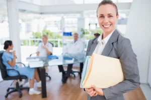 A case manager holding a patient's file meets with a team of physicians.