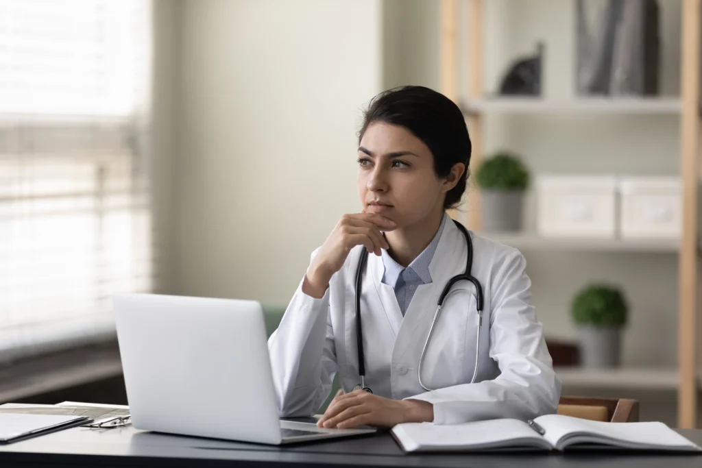 A doctor sits at her desk thinking about how to implement remote patient monitoring.